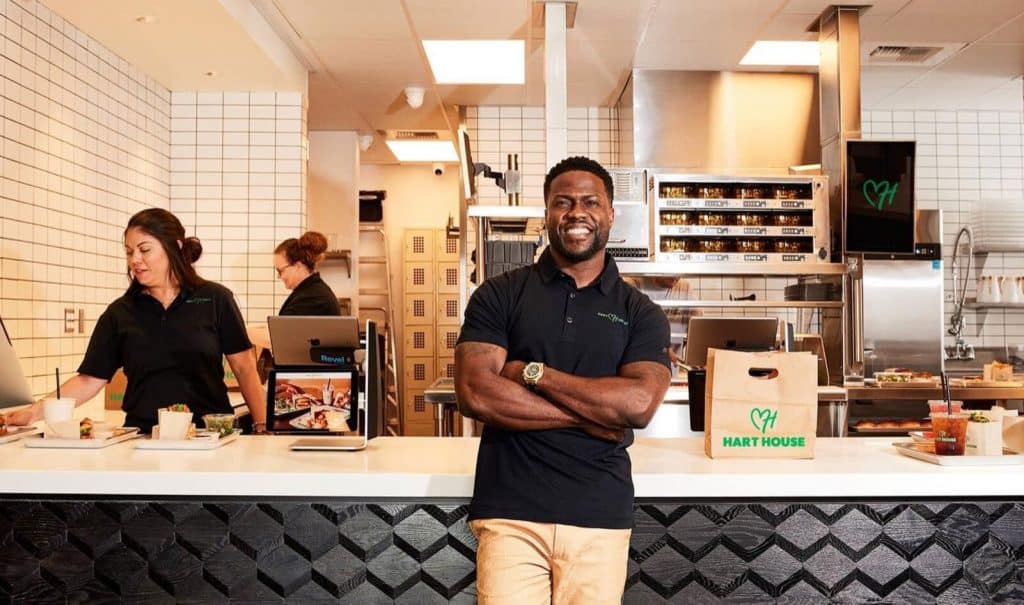 Actor and comedian Kevin Hart standing in front of his restaurant counter