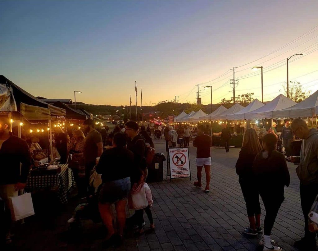 People attending Canyon Country farmers market at dusk
