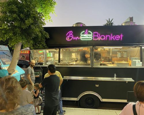 Bun & Blanket food truck parked by a tree on the street while customer waiting for their turn to order