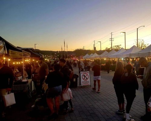 People attending Canyon Country farmers market at dusk
